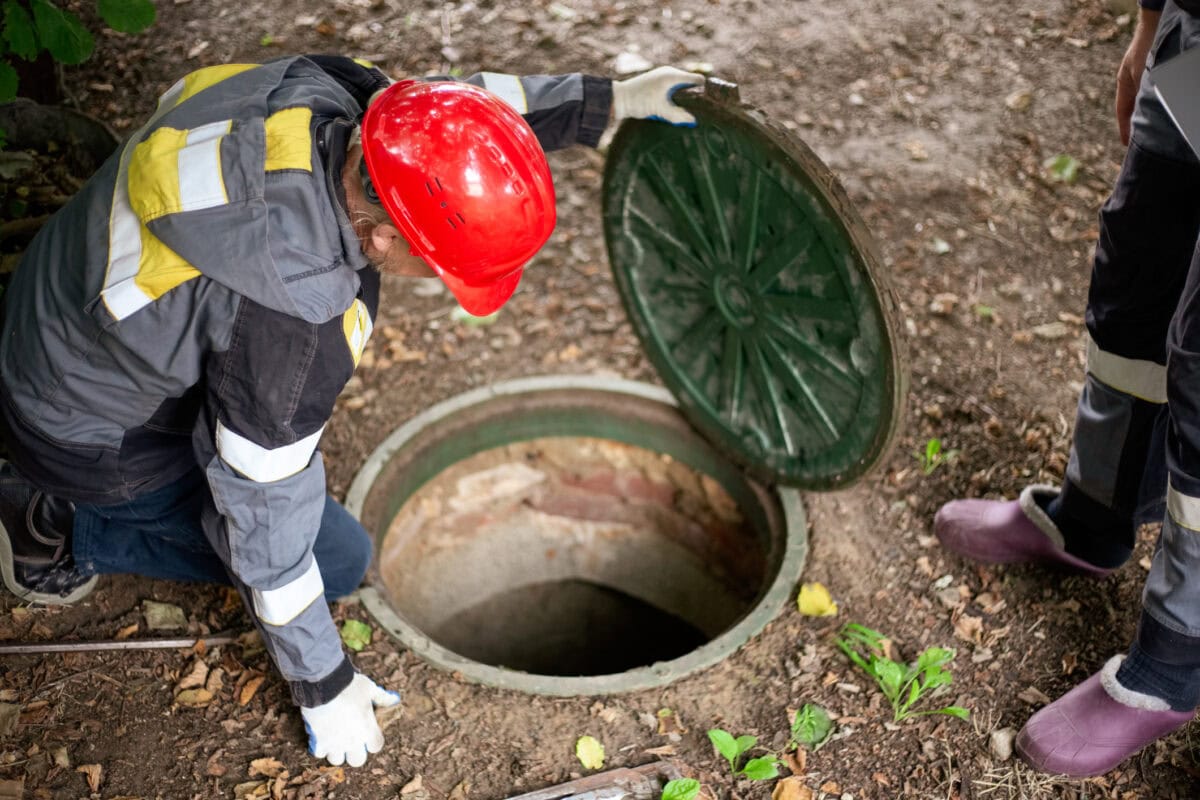 septic service company technician inspecting a residential septic tank